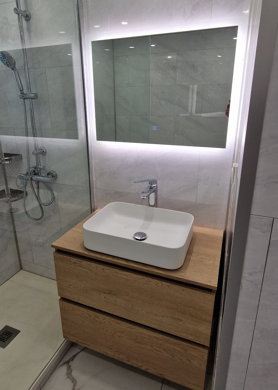 Miroir LED éclairé au-dessus d'un meuble vasque en bois, salle de bain réalisée par Coach Rénov